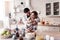 Pretty long-haired young woman in a white shirt and her husband standing in the kitchen