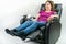 Pretty middle-age woman sitting in black leather recliner armchair. Checking blood pressure using portable blood pressure machine.