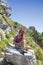 Pretty middle aged female hiker resting on big rock