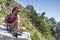 Pretty middle aged female hiker resting on big rock