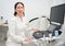 Pretty middle-aged woman uzist sits at workplace near ultrasound machine