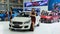 Pretty models stand next to a Suzuki Ciaz