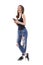 Pretty modern young woman laughing heartily white holding cellphone in trendy torn jeans.