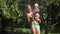 Pretty mother in underwear with baby daughter refreshing under water in garden. 4K