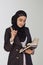 Pretty Muslim businesswoman in hijab holding stack of business documents, notepads and thinking - Good idea. Woman doing business