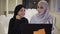 Pretty muslim businesswomen in hijab at office workplace or conference hall. Two smiling arabic woman working on laptop
