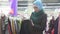 Pretty Muslim girl in hijab picks clothes in store