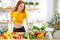 pretty nice woman with lots of healthy fresh food in kitchen. Concept of losing weight, sports and healthy eating