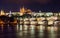 Pretty night time illuminations of Prague Castle, Charles Bridge and St Vitus Cathedral reflected in the Vltava river