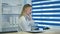 Pretty nurse using tablet and phone at hospital reception desk