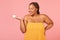 Pretty Obese Black Woman Holding Moisturizer Jar Over Pink Background