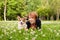 Pretty older woman with corgi dog in summer park