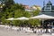 Pretty open cafÃ© with white parasols around traditional metal pavillon at Cais do SodrÃ© district in Lisbon, Portugal.
