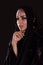 Pretty oriental woman in abaya on black background
