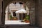 A pretty patio with umbrella ,colorful flowers and wooden doors, old part of town, Italy