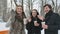 Pretty people waving hands in the winter snowy park