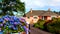 Pretty pink house with flowered garden in the green Irish countryside