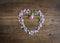 Pretty pink miniature rose buds and petals created a heart shape on a rustic pine table top