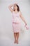 Pretty plump woman in pink dress with patent leather stiletto heels on white background in Studio