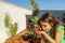 Pretty pre-adolescent girl smiling picking radishes in the urban garden on the terrace of her house