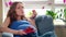 Pretty pregnant woman eating strawberries and smiling looking at camera