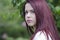 Pretty red hair teen front of green tree leaves
