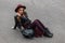 Pretty red-haired young woman in a vintage hat in a black jacket in trendy pants with a fashionable leather backpack enjoys