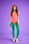 Pretty red-headed girl in pink bodysuit and green leggins in 80s style