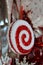 Pretty red and white fluffy ornament hanging from ribbon in holiday windows