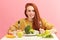 Pretty redhead caucasian woman sitting at table with healthy food and broccoli