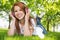 Pretty redhead listening to music in the park