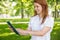 Pretty redhead using her tablet pc in the park