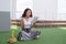 Pretty relaxed young woman reading a book at the lawn with fruit and juice