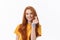 Pretty romantic young redhead woman making a heart gesture with a happy tender smile