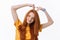 Pretty romantic young redhead woman making a heart gesture with a happy tender smile