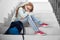 Pretty, sad schoolgirl sitting on staircase in school.