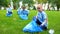 Pretty schoolgirl helping group of volunteers collecting garbage in bags at park