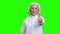 Pretty senior woman giving thumb up on green screen.