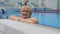 Pretty senior woman looks in camera in swimming pool
