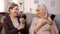 Pretty senior women applying make-up holding small mirrors, happy old friends