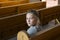 Pretty serious little girl sitting in church pew