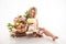 Pretty skinny girl with beautiful flowers on a white background in photo studio