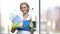 Pretty smiling chambermaid holding cleaning supplies.