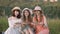 Pretty smiling girls, sitting on the grass and demonstrating snails on wooden plates