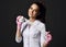 Pretty smiling woman doctor gynecologist or nurse in pink latex gloves and uniform stands holding medical bandage