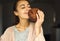 Pretty smiling woman holding and sniffing huge chocolate cookie