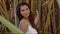 Pretty smiling woman leaning on bamboo tree