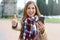 Pretty smiling young fashion woman using smart phone shows thumb up outdoor on Winter