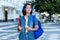 Pretty spanish female student with backpack and earphones