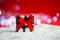Pretty spotted gift box on snow with garland lights on bokeh background